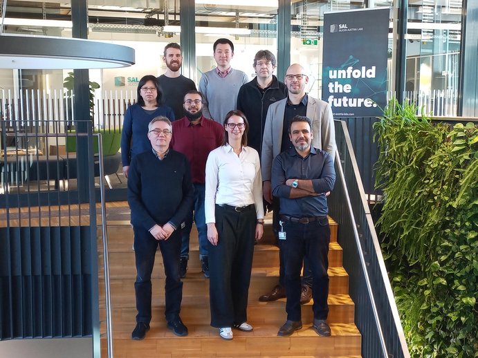 Gruppenfoto des Projektteams von SURFBOND mit 9 Personen auf den Stiegen im SAL-Gebäude in Villach