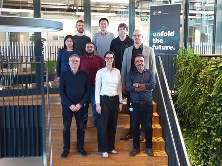 Gruppenfoto des Projektteams von SURFBOND mit 9 Personen auf den Stiegen im SAL-Gebäude in Villach