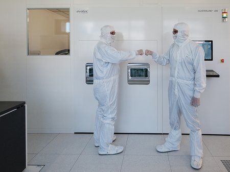 Two researchers standing in a clean room