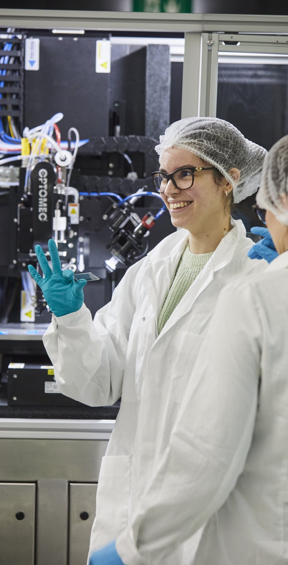 Emily Bezerra in protective clothing in the lab, smiling