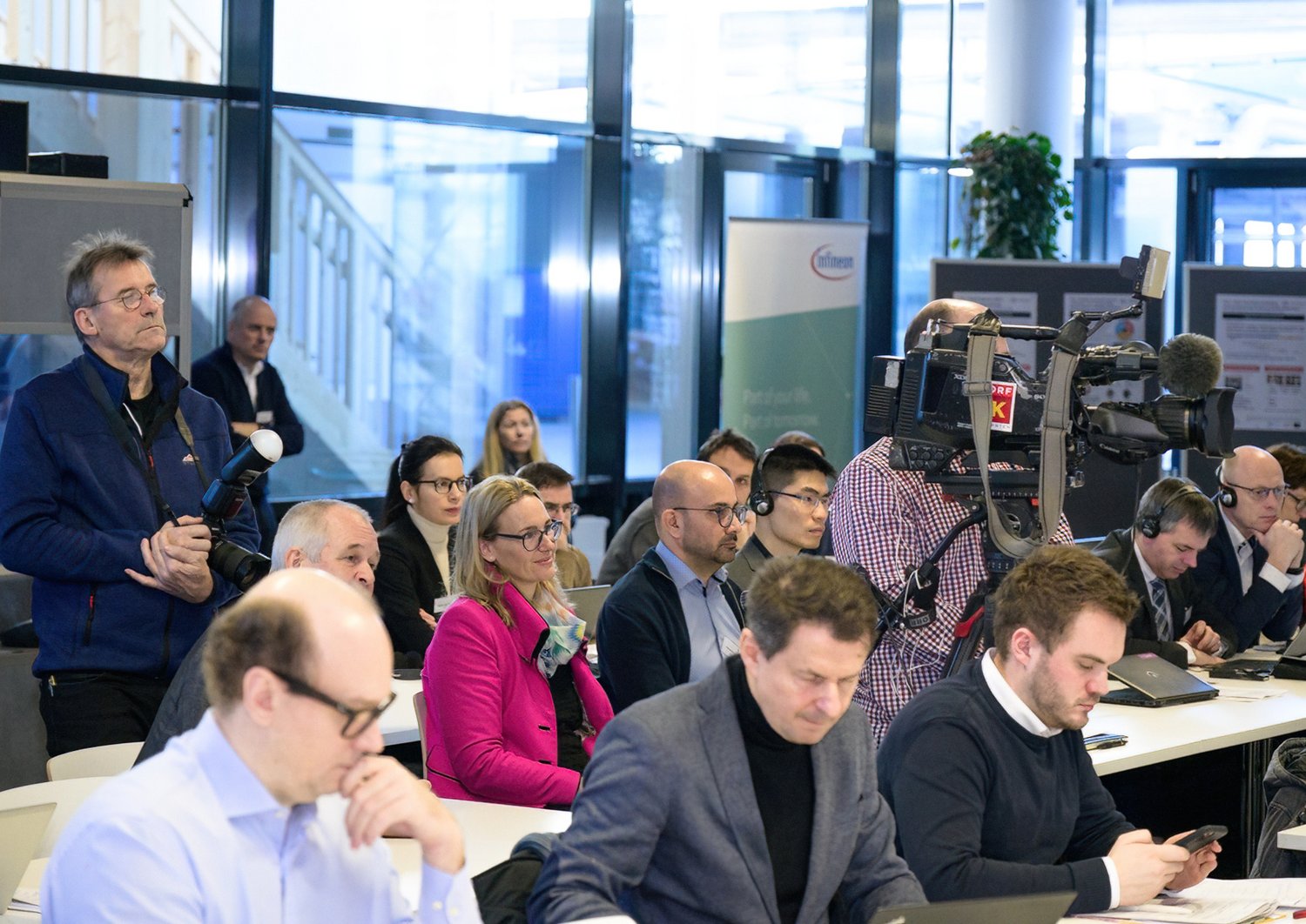 Teilnehmer:innen sitzen bei der Pressekonferenz und hören zu