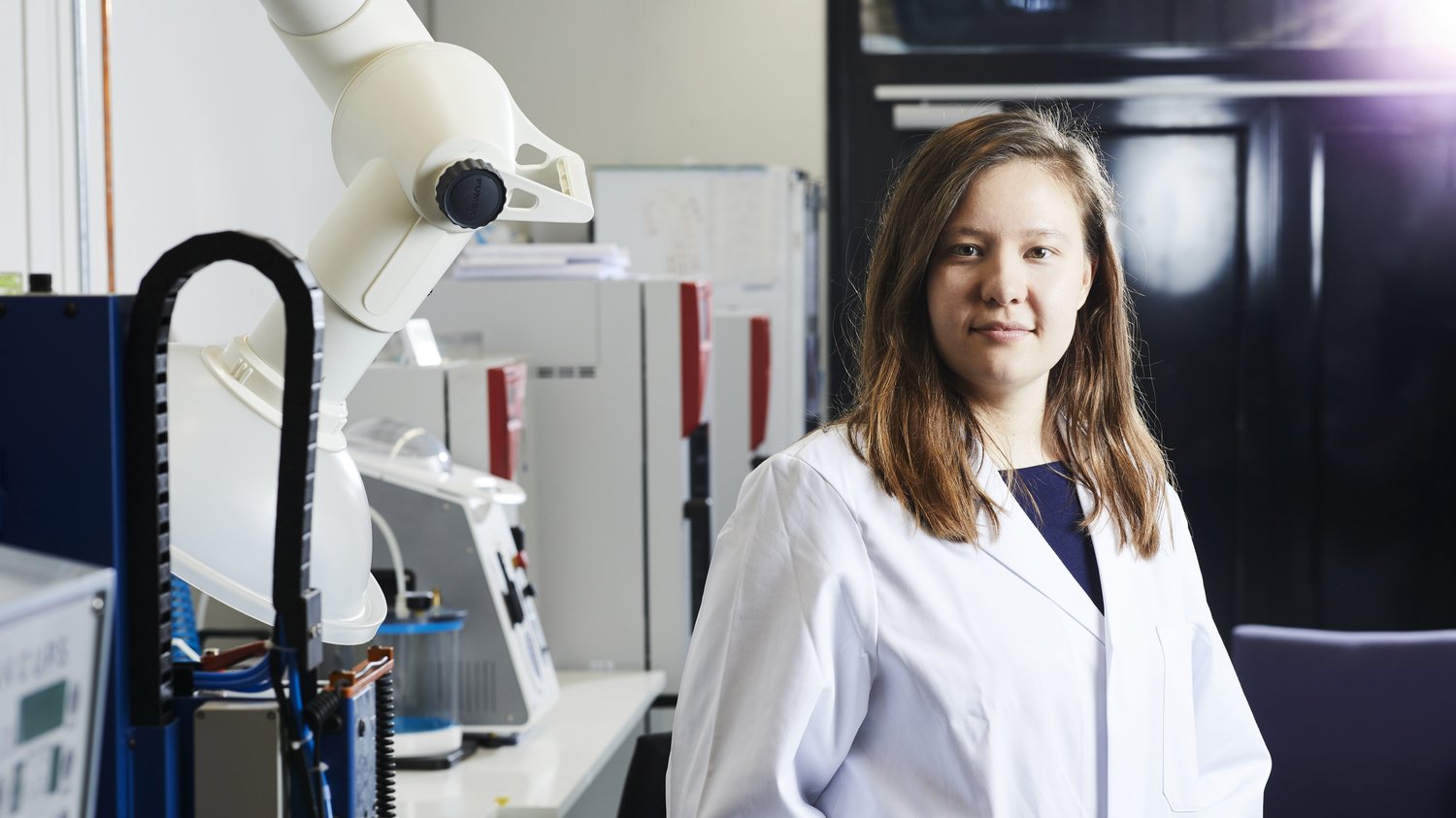 Tutku in a white lab coat in the lab