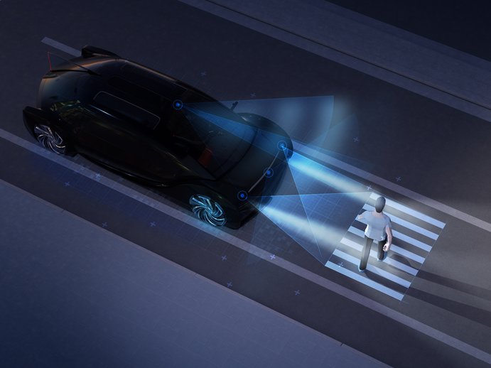 car stopping at a crosswalk at night to let a pedestrian pass