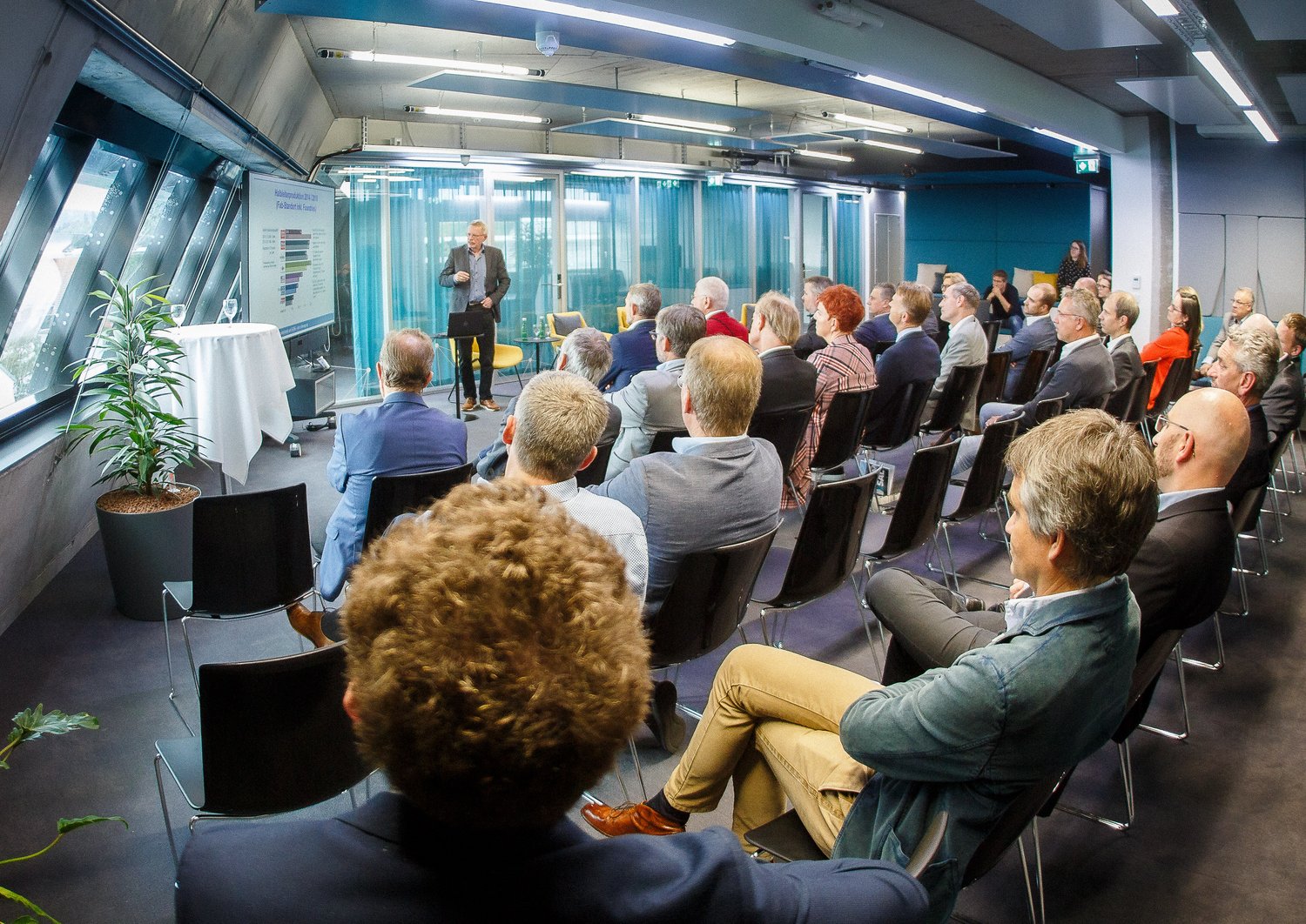 Robert Weigel hält einen Vortrag in Linz vor einer Gruppe an Menschen