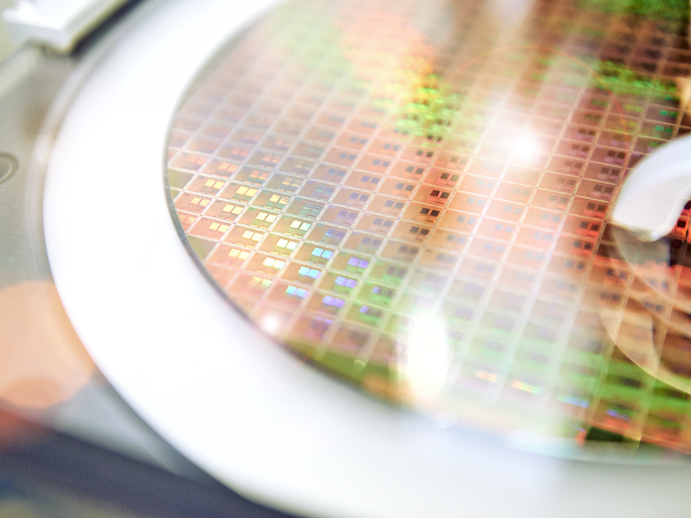 A close up of a wafer which is glowing in rainbow colors 