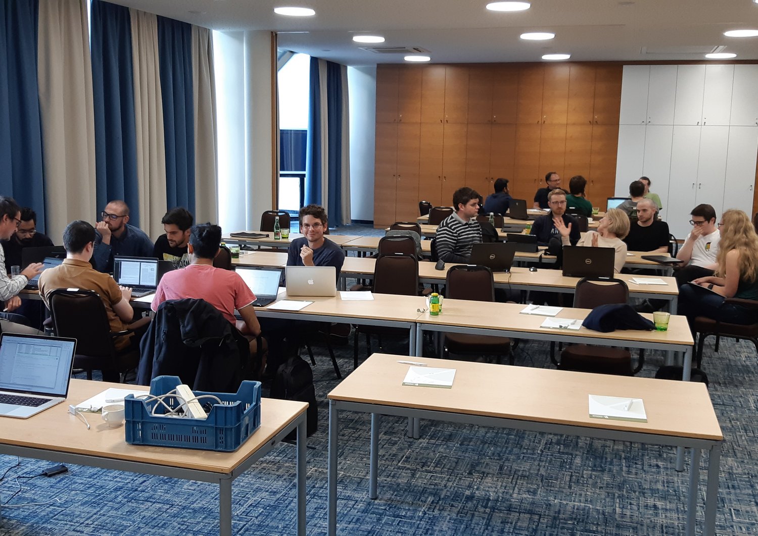 doctoral students working in groups at their laptops in a meeting room