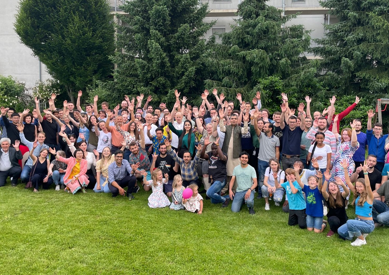 Gruppenbild mit etwa 100 Personen auf einer Wiese