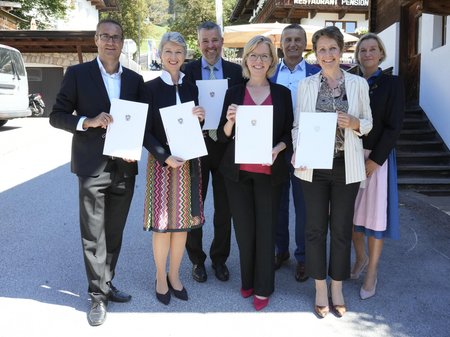 Christoph Ludwig, Gaby Schaunig, Gerald Murauer, Leonore Gewessler, Wilfried Enzenhofer, Sabine Herlitschka und Marion Mitsch, stehen nebeneinander mit einer Erklärung zur weiteren Unterstützung des Spitzenforschungszentrums bis 2030 in der Hand