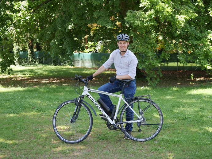 Herbert Hackl lehnt in Fahrradausrüstung an seinem Rad