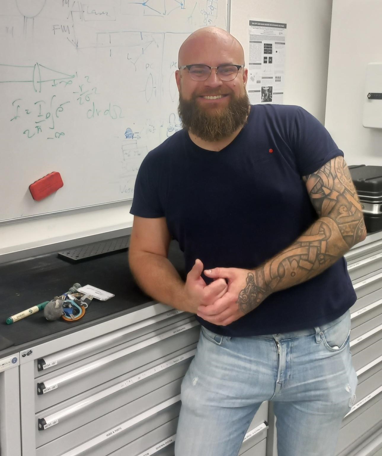 Matteo in the office in front of a blackboard that has formulas written on it